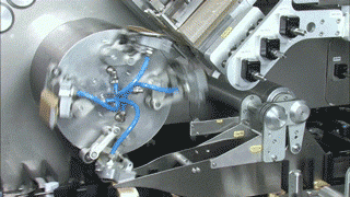 a rotary cartoning arm in operation on a blister packing and cartoning machine