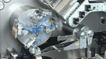 a rotary cartoning arm in operation on a blister packing and cartoning machine