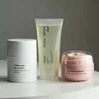 cosmetic products: jar containing lotion, tube containing gel and an open jar containing cream